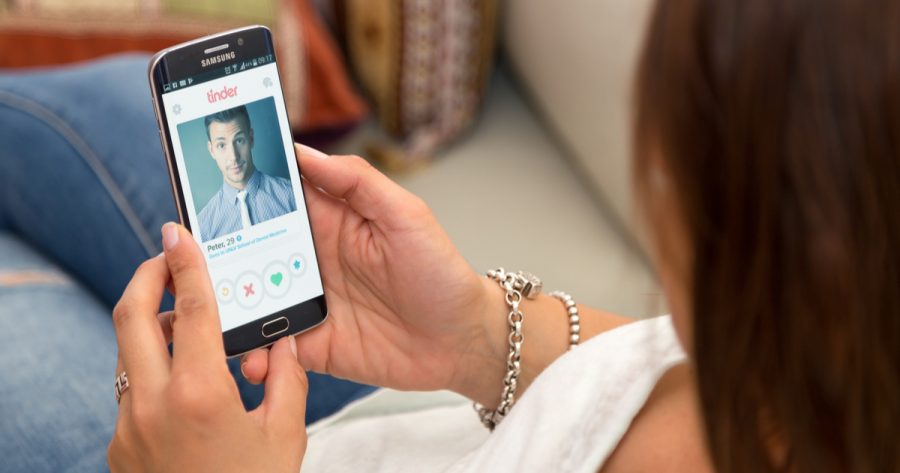 holding a smartphone with Tinder application on the screen